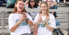 Two students pose in the bleachers at UMW&rsquo;s Homecoming.