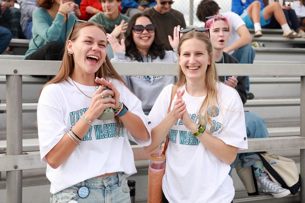 Two students pose in the bleachers at UMW&rsquo;s Homecoming.