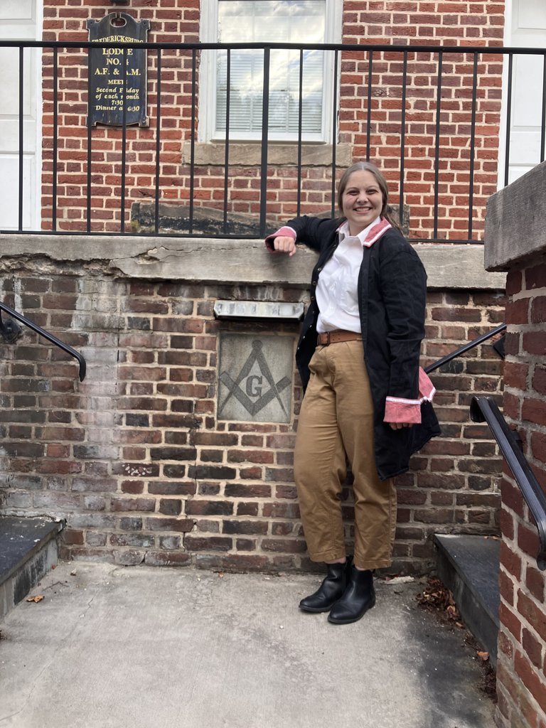 A student dressed as George Washington leaning against the Masonic building in Fredericksburg.