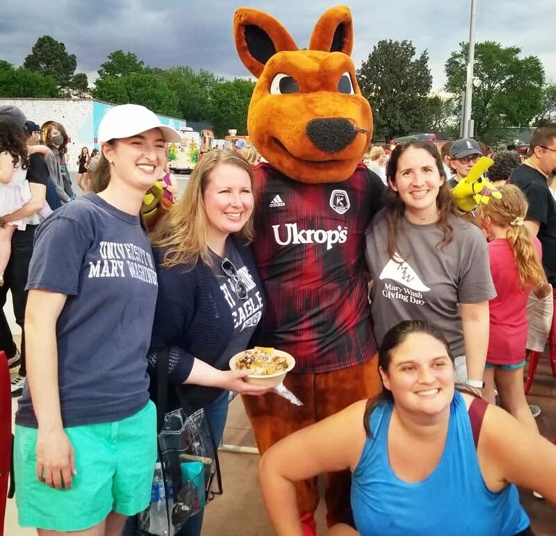 A group of four people and a kangaroo mascot.