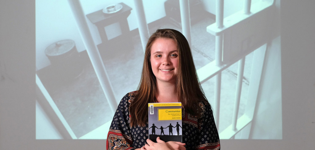 Kristen Powell with a photograph of Nelson Mandela's cell behind her, Monday, April 6, 2015. (Photo by Norm Shafer).