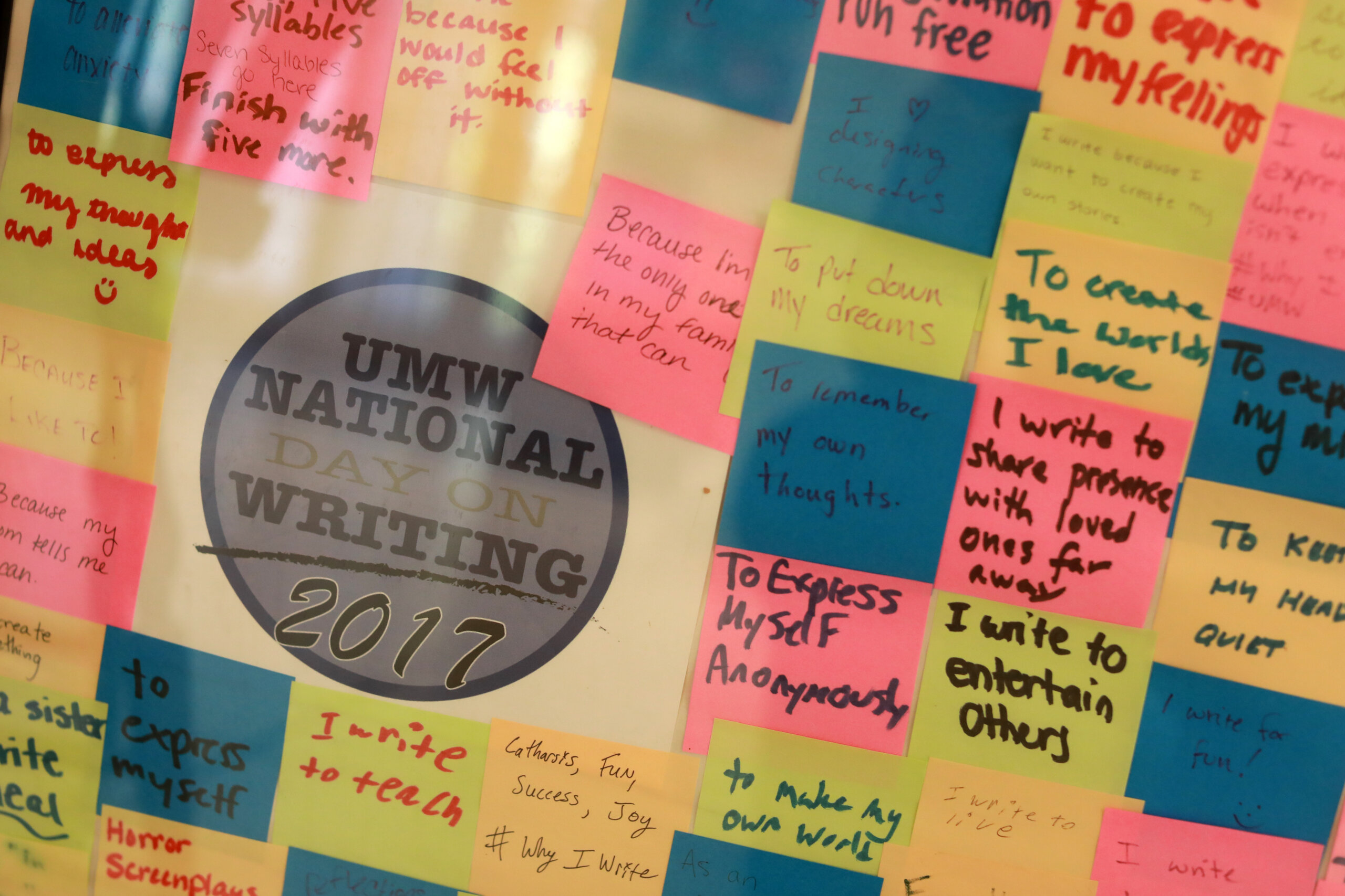 A sign for the "UMW National Day on Writing 2017" surrounded by sticky notes that say why people like writing.