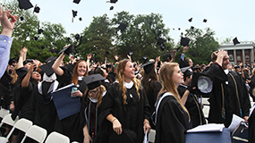 Graduates celebrate by throwing their mortarboards in the air at the graduation ceremony.